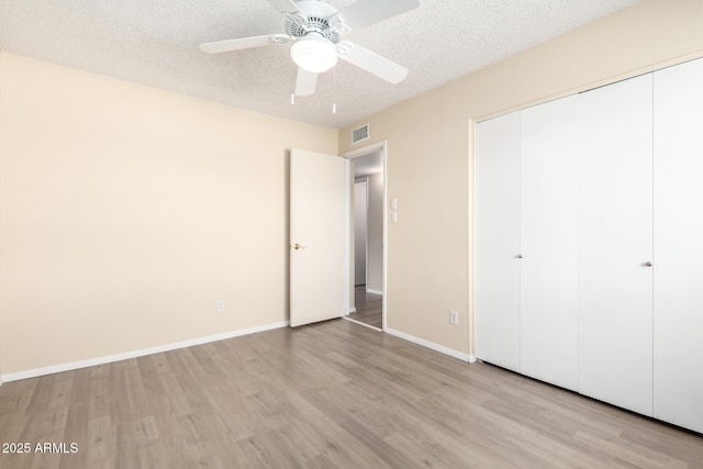 unfurnished bedroom featuring visible vents, a textured ceiling, and wood finished floors