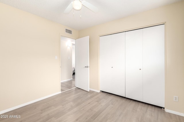 unfurnished bedroom with a closet, baseboards, visible vents, and light wood finished floors