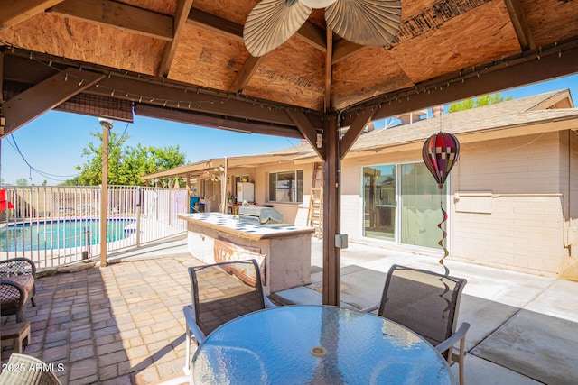 view of patio with outdoor dry bar, outdoor dining space, a fenced in pool, and fence