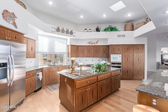 24801 N Vado Ct, Rio Verde, AZ 85263 - kitchen with stainless steel appliances, a kitchen island, a sink, light wood-style flooring, and recessed lighting