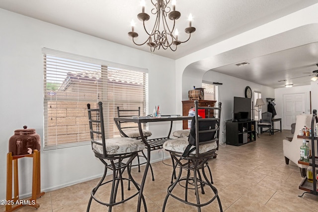 2202 S Lawther Dr, Apache Junction, AZ 85120 - dining area with arched walkways, light tile patterned floors, ceiling fan, and a chandelier