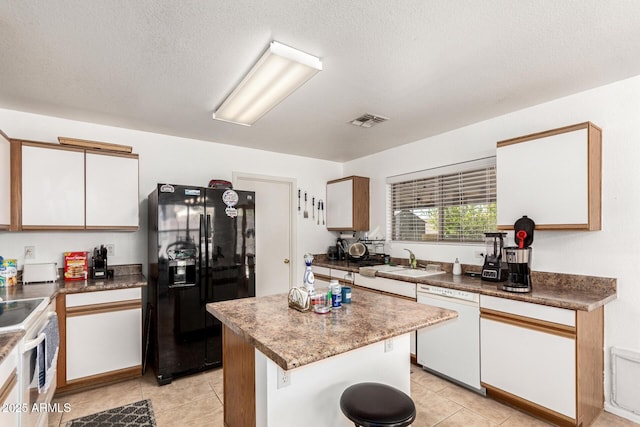 2202 S Lawther Dr, Apache Junction, AZ 85120 - kitchen featuring white appliances, white cabinetry, light tile patterned floors, a center island, and a textured ceiling