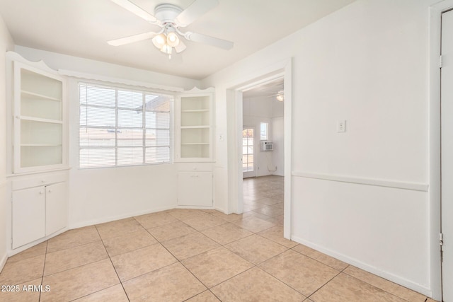 unfurnished room featuring light tile patterned floors, a ceiling fan, and baseboards