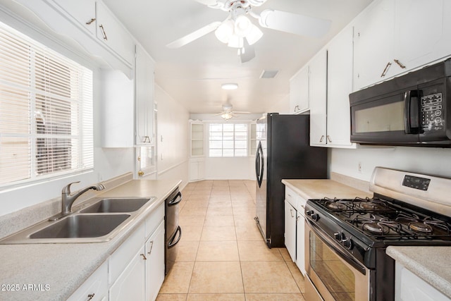 kitchen featuring black appliances, white cabinets, light tile patterned flooring, and a sink