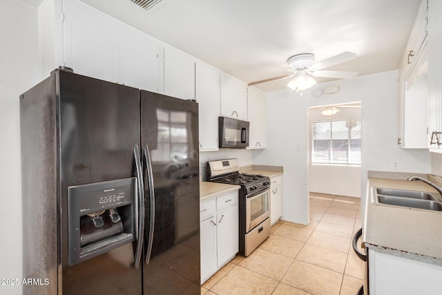 kitchen featuring a sink, black appliances, white cabinets, and light tile patterned floors