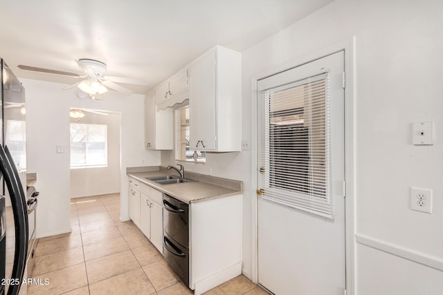 kitchen featuring light tile patterned floors, freestanding refrigerator, a sink, light countertops, and white cabinetry