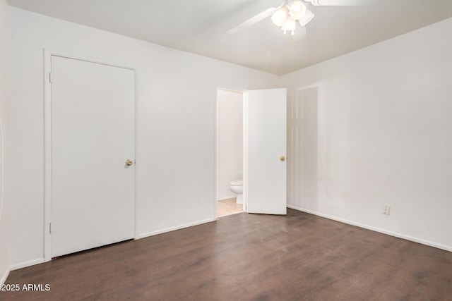 unfurnished bedroom featuring ceiling fan, ensuite bath, baseboards, and wood finished floors