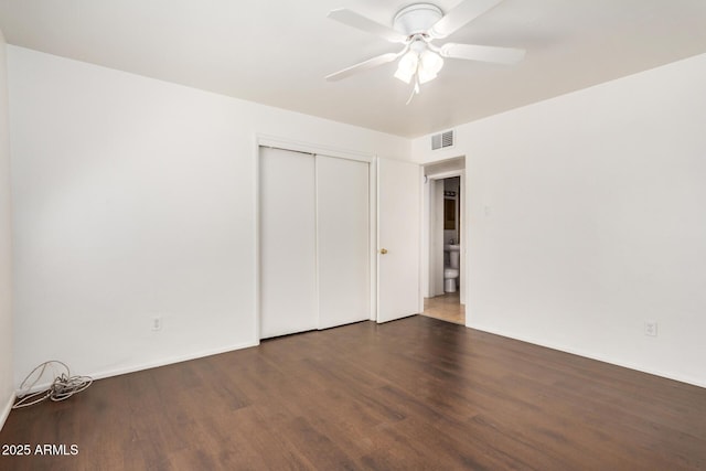 unfurnished bedroom with wood finished floors, visible vents, a closet, and ceiling fan