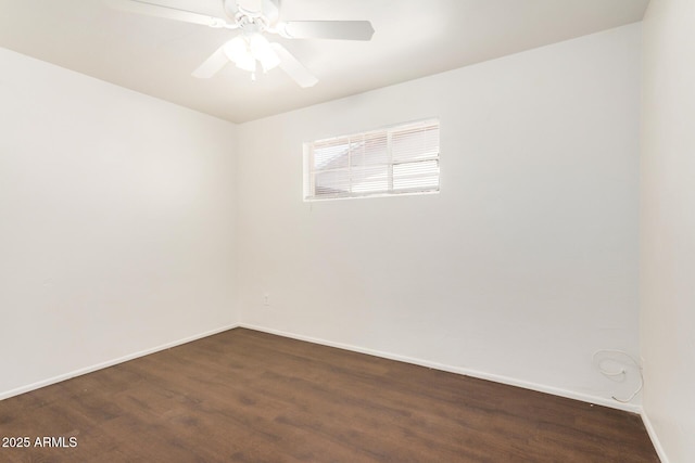 unfurnished room with baseboards, a ceiling fan, and dark wood-style flooring