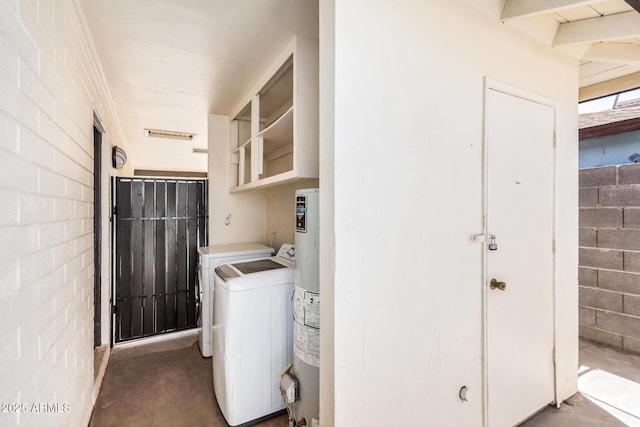 laundry room featuring laundry area, concrete block wall, gas water heater, and washing machine and clothes dryer