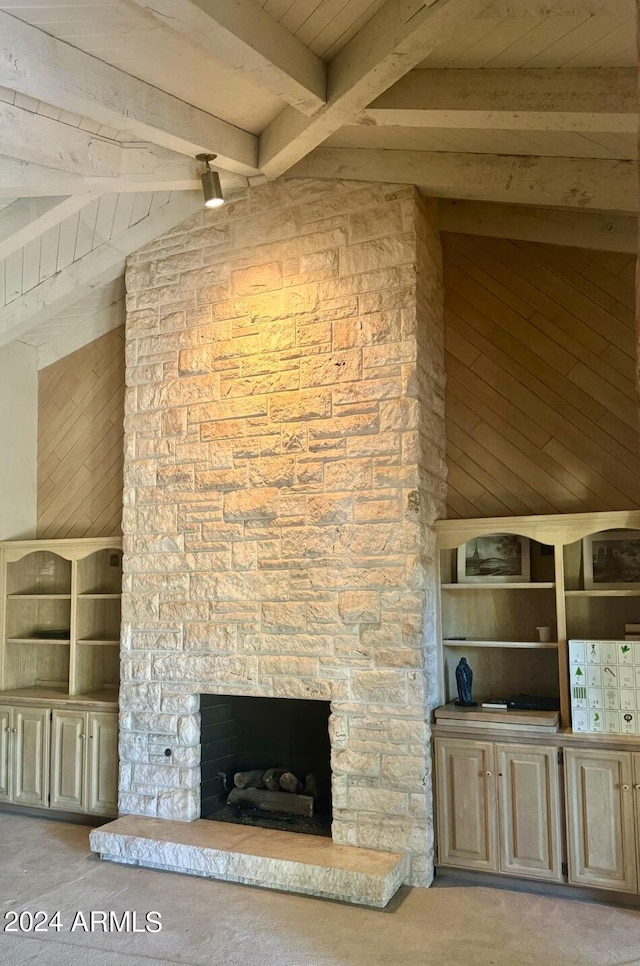 unfurnished living room with wooden walls, lofted ceiling with beams, wood ceiling, and a fireplace