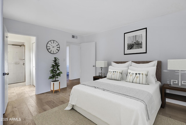 bedroom featuring wood finished floors and visible vents