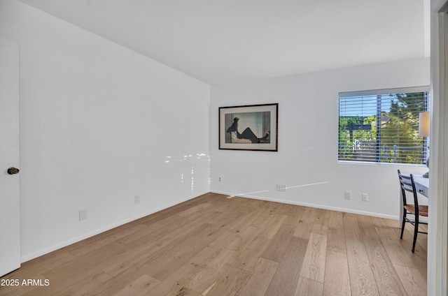 unfurnished room with baseboards and light wood finished floors