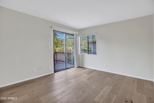 empty room with baseboards and wood-type flooring