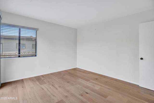 empty room with hardwood / wood-style floors and baseboards