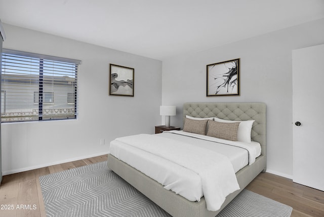 bedroom with wood finished floors and baseboards