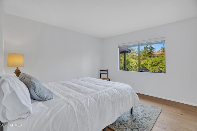 bedroom featuring baseboards and wood finished floors