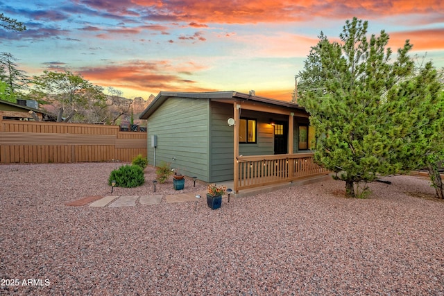 view of outbuilding with covered porch and fence