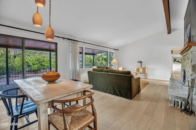 dining space featuring baseboards, vaulted ceiling with beams, and light wood finished floors