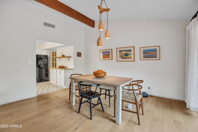 dining room with beam ceiling, visible vents, light wood-type flooring, and baseboards