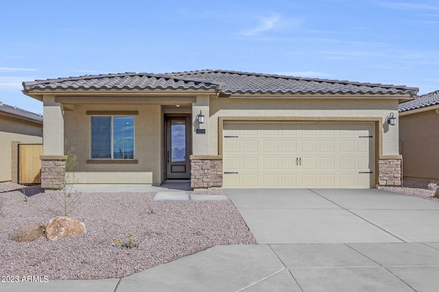 prairie-style home featuring a garage, driveway, stone siding, and stucco siding