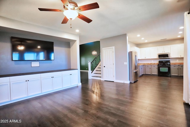 unfurnished living room with dark wood finished floors, recessed lighting, stairway, a ceiling fan, and baseboards