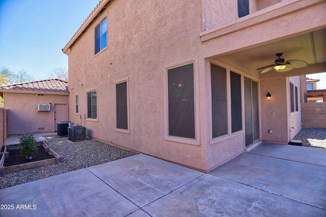 exterior space with fence, a patio area, a tile roof, and stucco siding