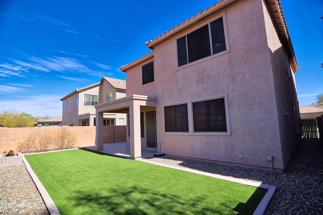 rear view of house featuring a patio area, a fenced backyard, and stucco siding