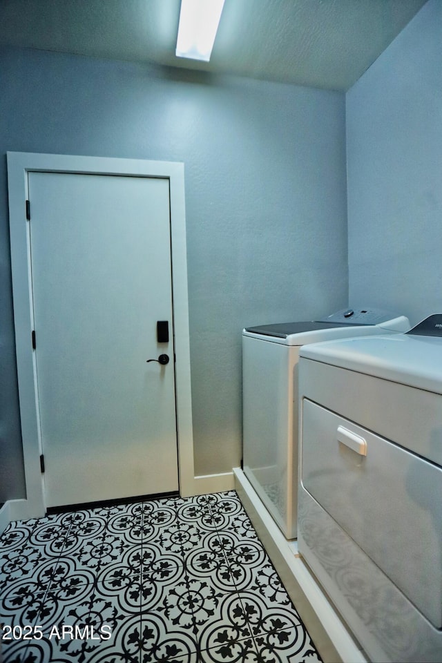 clothes washing area with laundry area, light tile patterned floors, and washing machine and clothes dryer