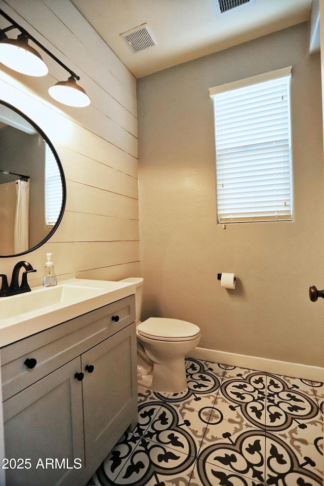 bathroom featuring visible vents, vanity, toilet, and tile patterned floors