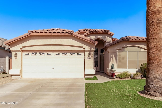 mediterranean / spanish house with concrete driveway, an attached garage, a tile roof, and stucco siding