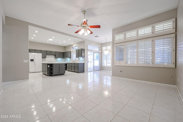 unfurnished living room featuring sink and ceiling fan