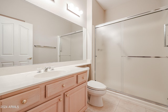 bathroom featuring walk in shower, vanity, tile patterned flooring, and toilet