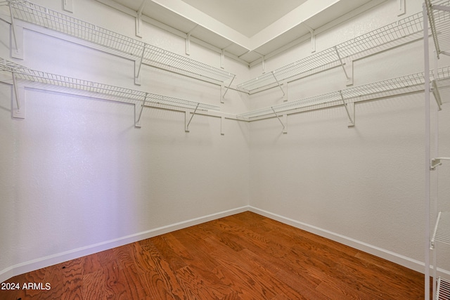 walk in closet with hardwood / wood-style floors