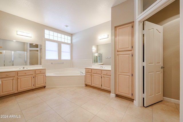 bathroom with vanity, plus walk in shower, a textured ceiling, and tile patterned floors