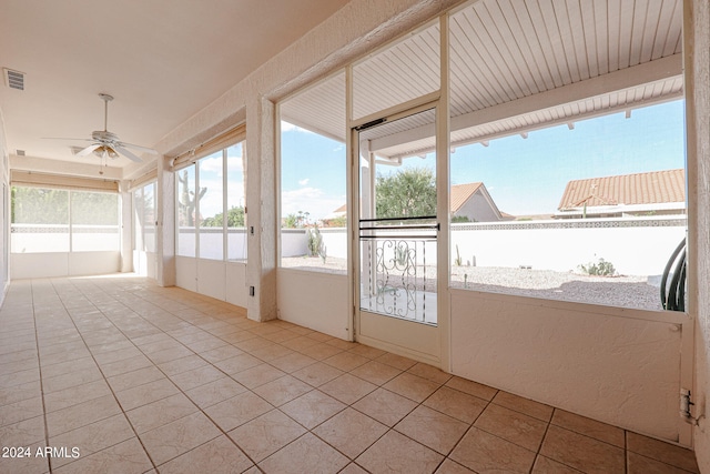 unfurnished sunroom with ceiling fan