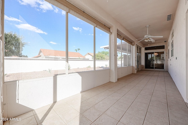 unfurnished sunroom featuring ceiling fan