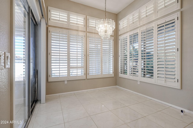 spare room featuring an inviting chandelier and plenty of natural light