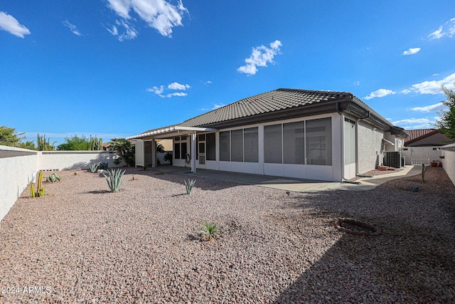 rear view of house with a sunroom, a patio, and central AC unit