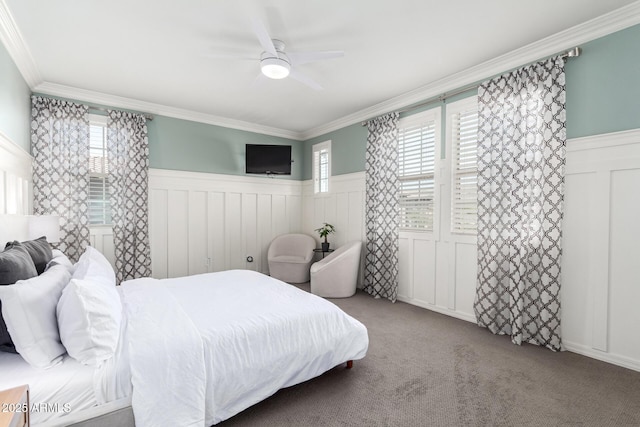 carpeted bedroom featuring multiple windows, wainscoting, and crown molding