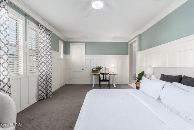 carpeted bedroom featuring visible vents, wainscoting, ceiling fan, and ornamental molding