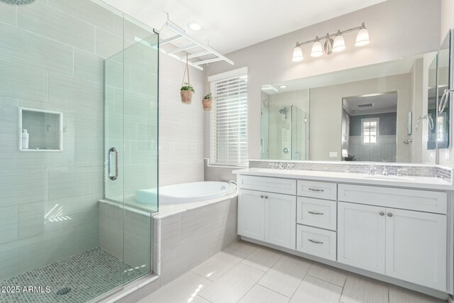 full bathroom with double vanity, a stall shower, a sink, tile patterned flooring, and a bath