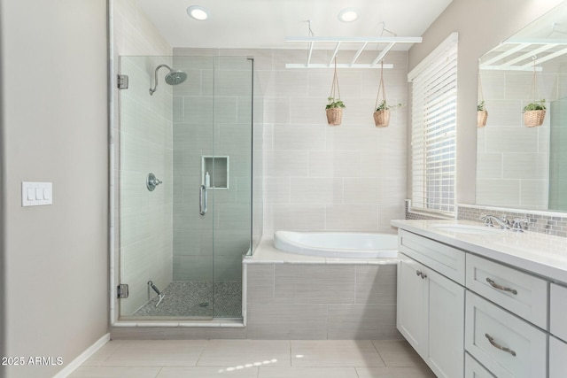 bathroom featuring a bath, tile patterned floors, a stall shower, and vanity