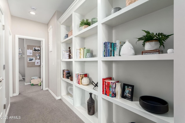 hall featuring baseboards and carpet