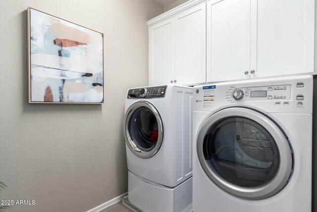 laundry area featuring cabinet space, baseboards, and washer and clothes dryer