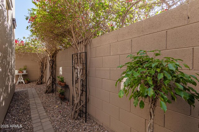 view of side of home featuring concrete block siding and a fenced backyard