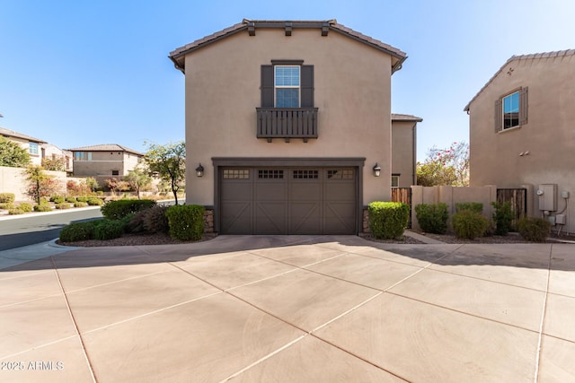 view of front of property with fence, an attached garage, stucco siding, concrete driveway, and a tiled roof