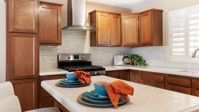 524 W Fairway Dr Unit 10, Mesa, AZ 85201 - kitchen featuring wall chimney range hood, stainless steel gas range oven, a sink, and backsplash