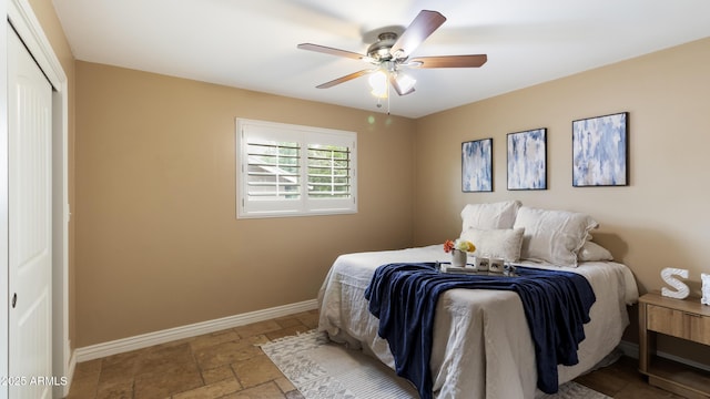 524 W Fairway Dr Unit 10, Mesa, AZ 85201 - bedroom with baseboards, stone tile flooring, a closet, and ceiling fan