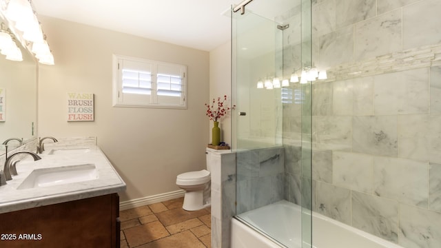 524 W Fairway Dr Unit 10, Mesa, AZ 85201 - bathroom with double vanity, bath / shower combo with glass door, toilet, baseboards, and stone tile floors